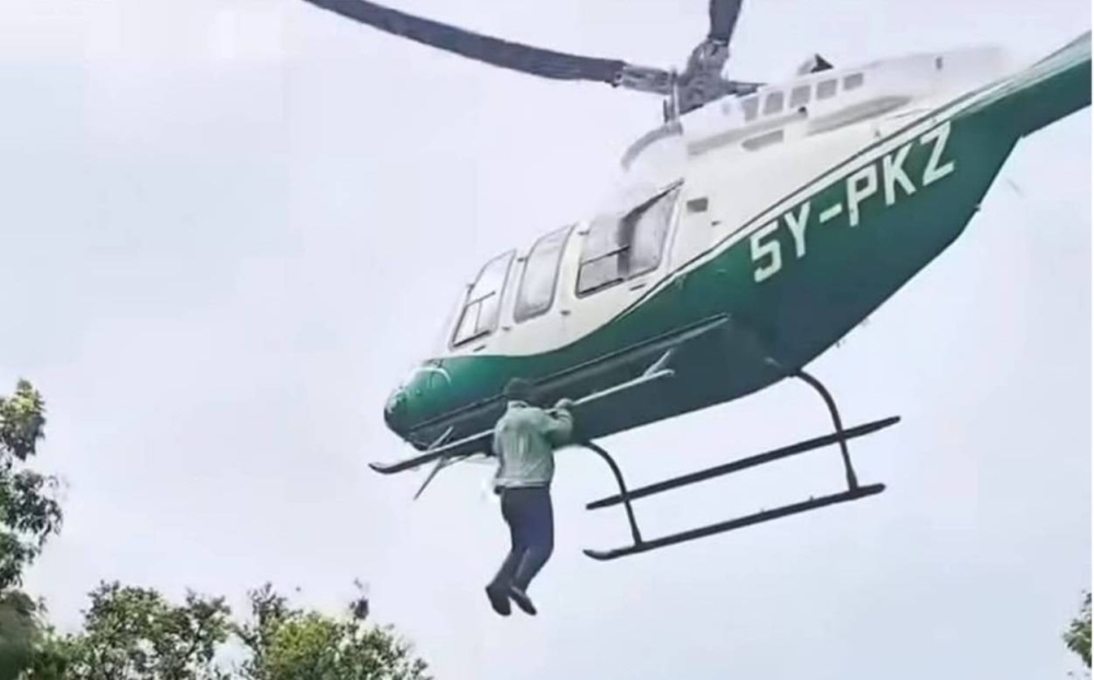 لحظات رعب.. شاب كيني يخاطر بحياته ويتعلق بمروحية أثناء حفل زفاف !